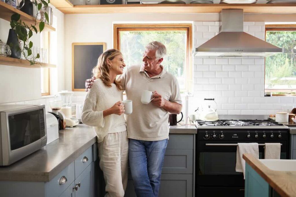 A couple standing in their kitchen discussing their will.